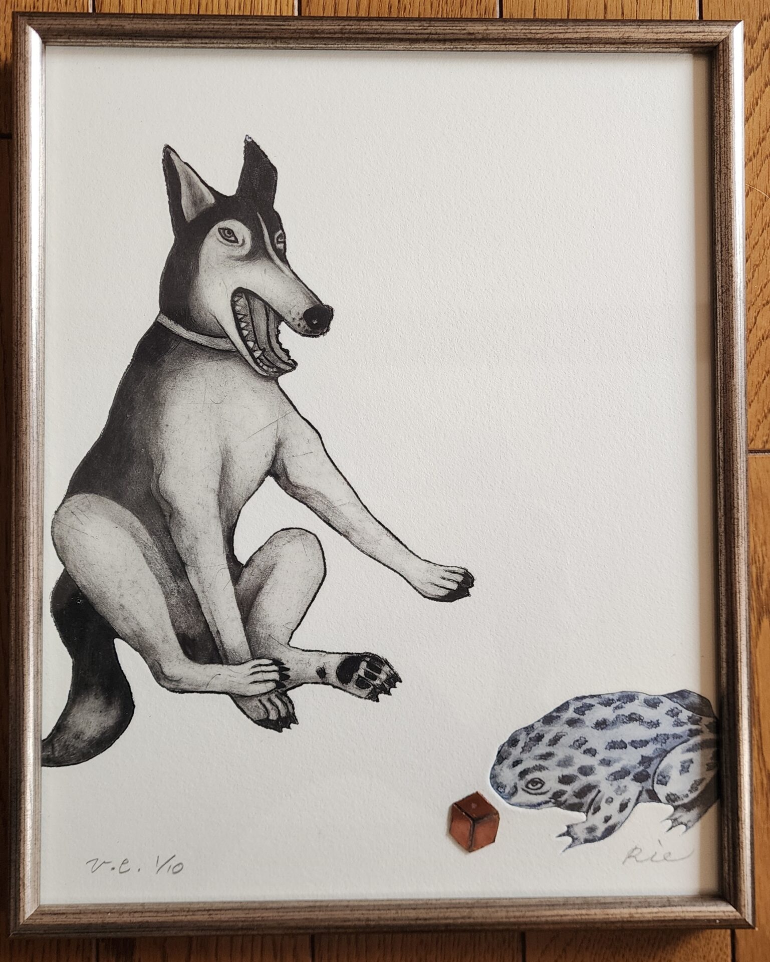 木製フレーム内のモノクロームエッチング。二足歩行する犬が、開いた口で笑顔を浮かべており、右下に赤いサイコロと斑点模様の生物が描かれている。署名と番号付きのリトグラフ作品